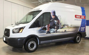 A white van that has an image of a man and says raise level on the side